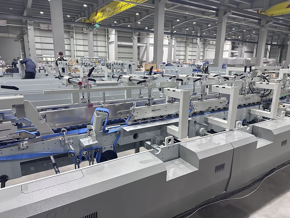 Detailed view of the mechanical structure and folding belts of a Sinosun automatic folder gluer machine.