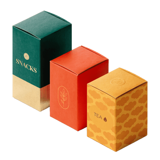 Folded food and tea packaging boxes showcasing folder gluer applications. The green box reads SNACKS, the yellow reads TEA.