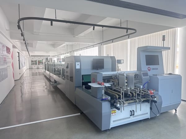 SINOSUN automatic carton folder gluer machine displayed in a modern factory showroom