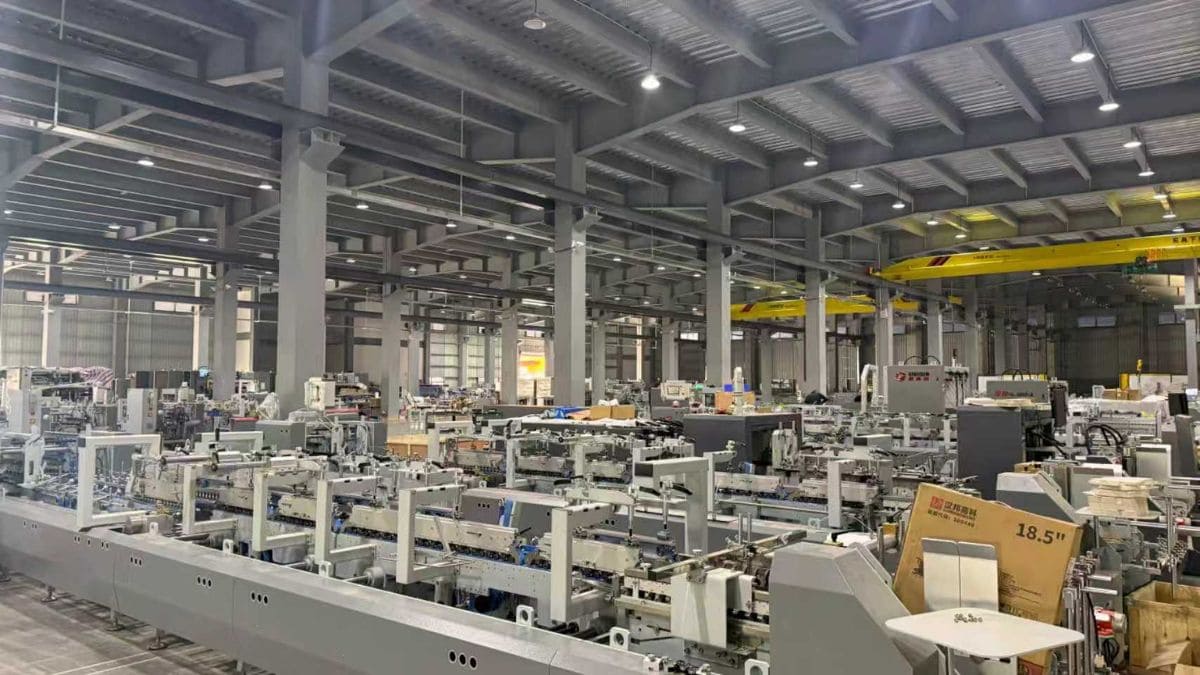 Automated folder gluer machine processing corrugated cartons